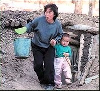 Семья северокорейских беженцев около своего импровизированного жилища (иллюстрация отсутствует в опубликованном тексте)